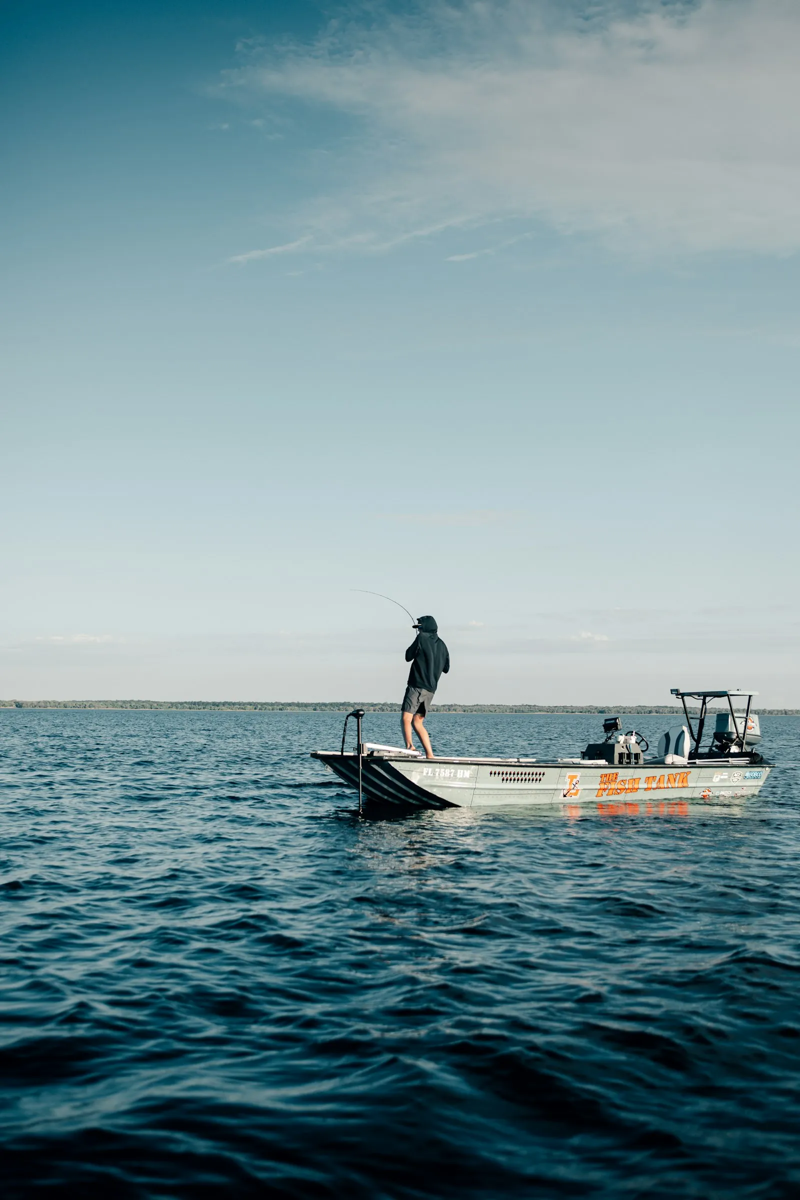 Angler standing on a skiff on calm open water