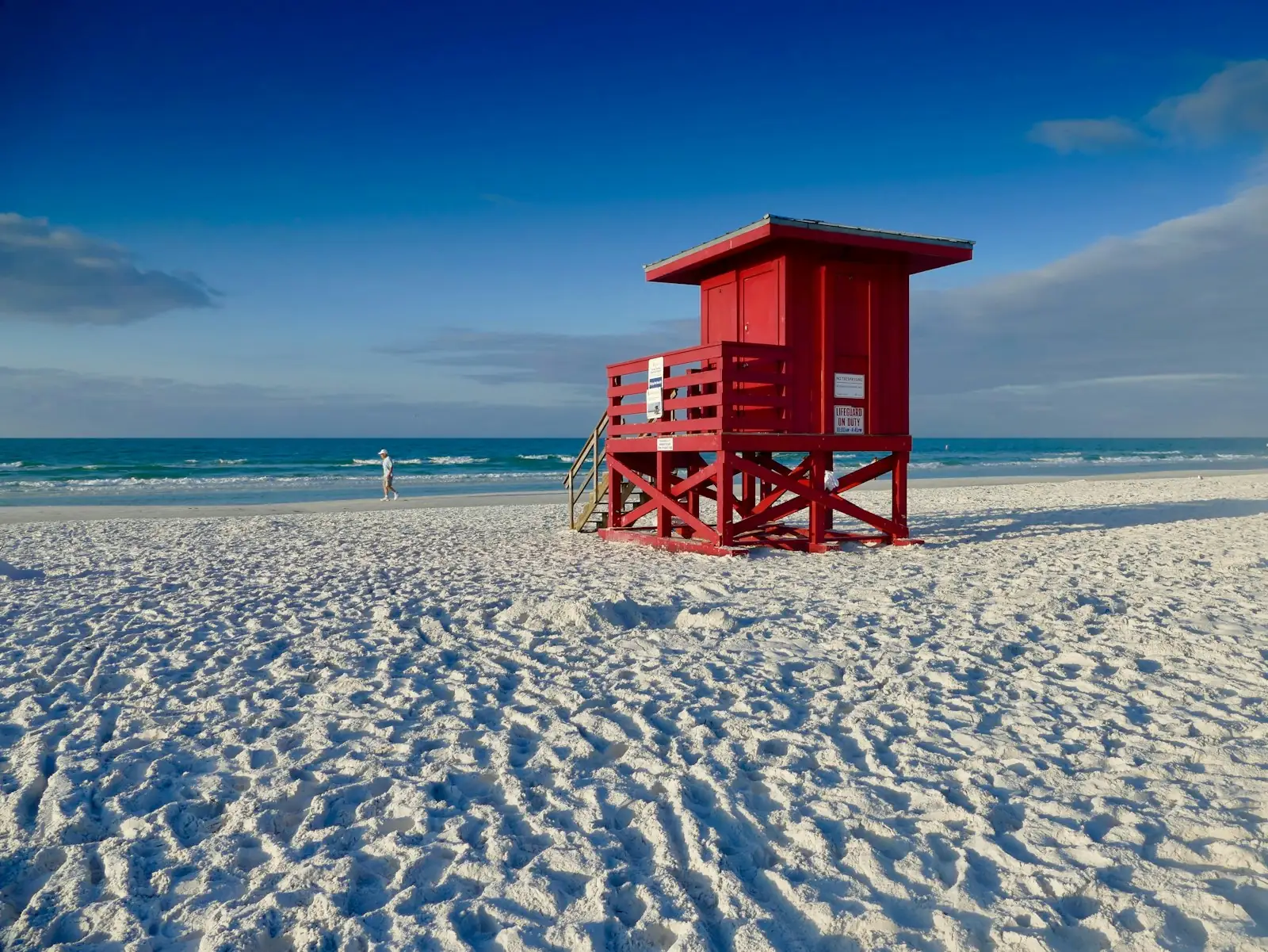 Red lifeguard stand on a white-sand Gulf Coast beach