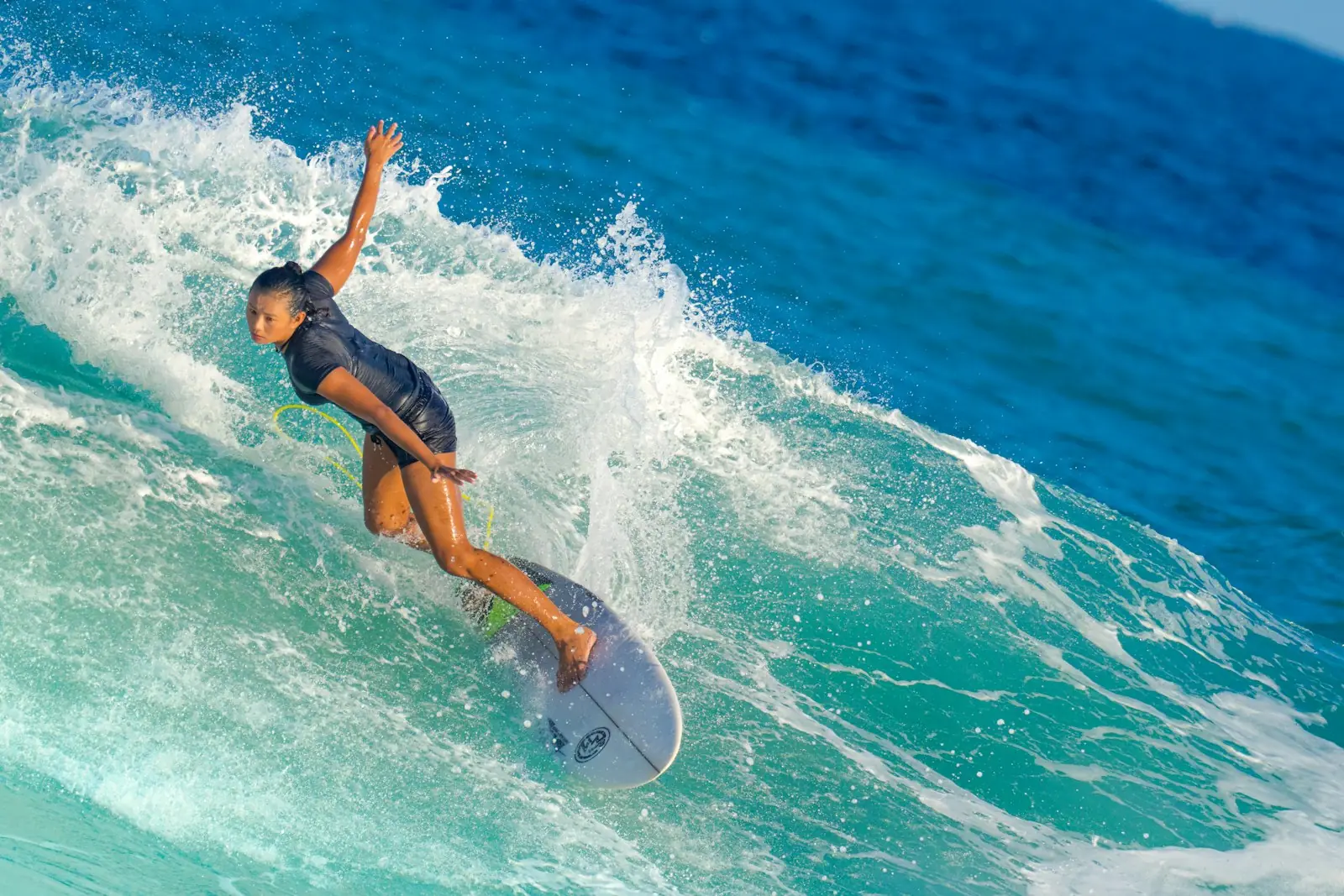 Surfer carving a turquoise wave
